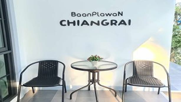 A wall with the text "BaanPlowon CHIANGRAI" and two chairs and a table in front of it. - Baan Plawan Resort Chiang Rai (Chiang Rai)