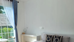 A modern bedroom with a large bed, a desk, and a chair. - Baan Plawan Resort Chiang Rai (Chiang Rai)