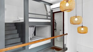 A modern hotel room with a bunk bed, a wooden staircase, and a glass shower enclosure. - Mai Hotel (Ho Chi Minh City)