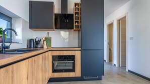 Een moderne keuken met een inbouwoven, een spoelbak en houten keukenkastjes.