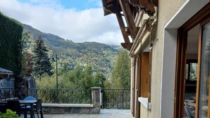 A patio with stone flooring, a wooden pergola, and a view of a mountainous landscape. - Très Spacieux T4 Dans un Chalet Traditionnel Entièrement Rénové, en Coeur de Village (Saint Lary Soulan)