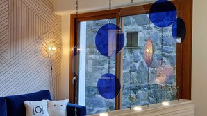 A modern living room with a blue sofa, a wooden coffee table, and hanging blue glass orbs. - Très Spacieux T4 Dans un Chalet Traditionnel Entièrement Rénové, en Coeur de Village (Saint Lary Soulan)