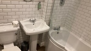 A bathroom with a toilet, pedestal sink, and a bathtub. - The Lobster  (Sheringham)