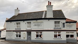 A building with a sign reading "The Lobster" on Wyndham Street, featuring a traditional facade, multiple windows, and a tiled roof. - The Lobster  (Sheringham)