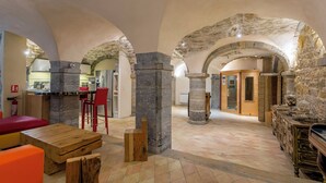 A spacious interior with stone arches, a kitchen area, and a dining space with wooden furniture. - Appartement de Standing au Cœur du Vieux Lyon (Lyon)
