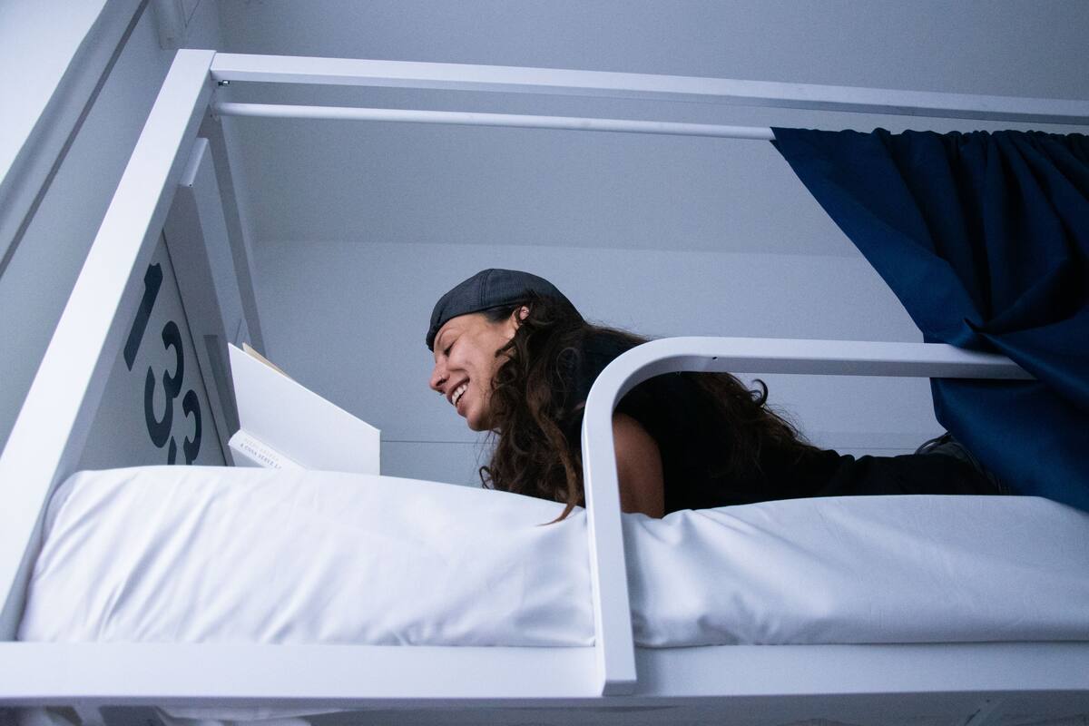 A bunk bed with a white frame and a number "133" on the wall.