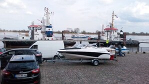 A marina with boats docked, a trailer with a boat, and a white van. - Gästehaus Barbara mit Garage in 26919 Brake (Brake (Unterweser))