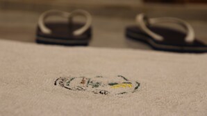 Un gros plan d’un tapis avec une serviette et des chaussons.
