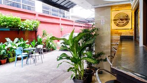 An indoor patio area with potted plants, seating, and a counter. - Usman Halal Home (Bangkok)