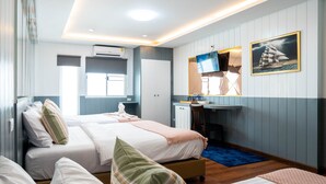A hotel room with two beds, a desk, a TV, and a window. - Usman Halal Home (Bangkok)