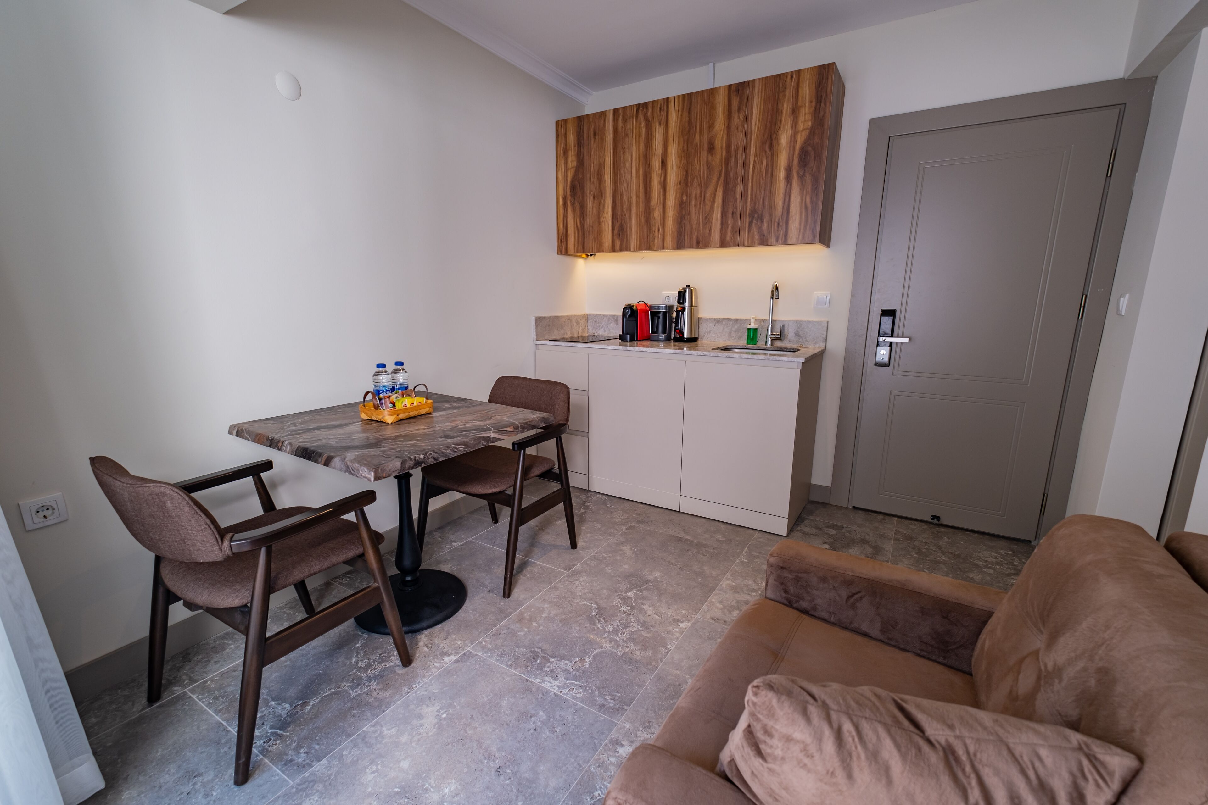 A compact living space with a dining area, kitchenette, and a sofa.
