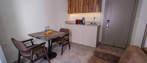 A compact living space with a dining area, kitchenette, and a sofa.