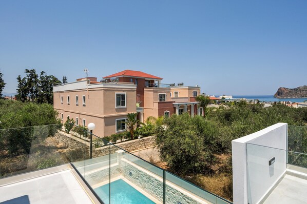 A modern building with a swimming pool, surrounded by greenery and overlooking a coastal area. - Villa Megalith (Chania)