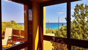 Habitación con amplios ventanales que ofrecen vistas al mar y al verdor.