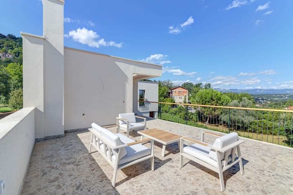 A rooftop terrace with outdoor seating and a view of the surrounding landscape. - Villa Dreamview by Aneo Travel (Matulji)