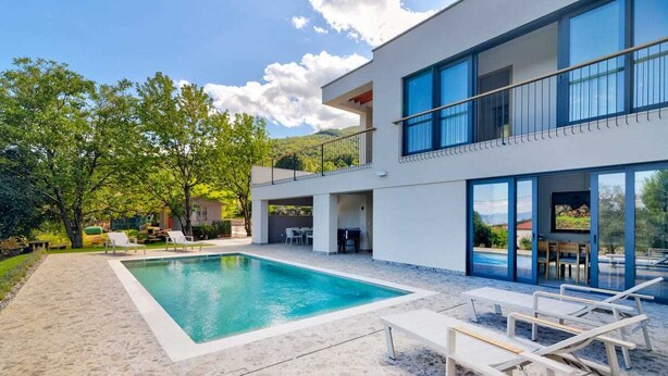 A modern two-story house with a swimming pool, outdoor seating, and a balcony overlooking a lush garden. - Villa Dreamview by Aneo Travel (Matulji)