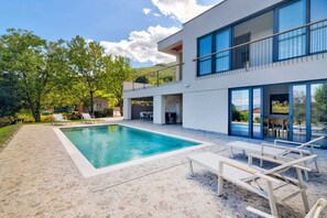A modern two-story house with a swimming pool, outdoor seating, and a balcony overlooking a lush garden. - Villa Dreamview by Aneo Travel (Matulji)