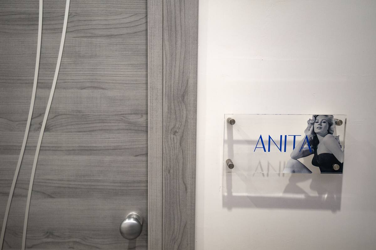 A door with a nameplate reading "ANITA" and a partial view of a wooden door frame.
