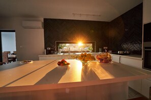 Enjoy cooking in this sleek kitchen with a central island, coffee maker, and large window.