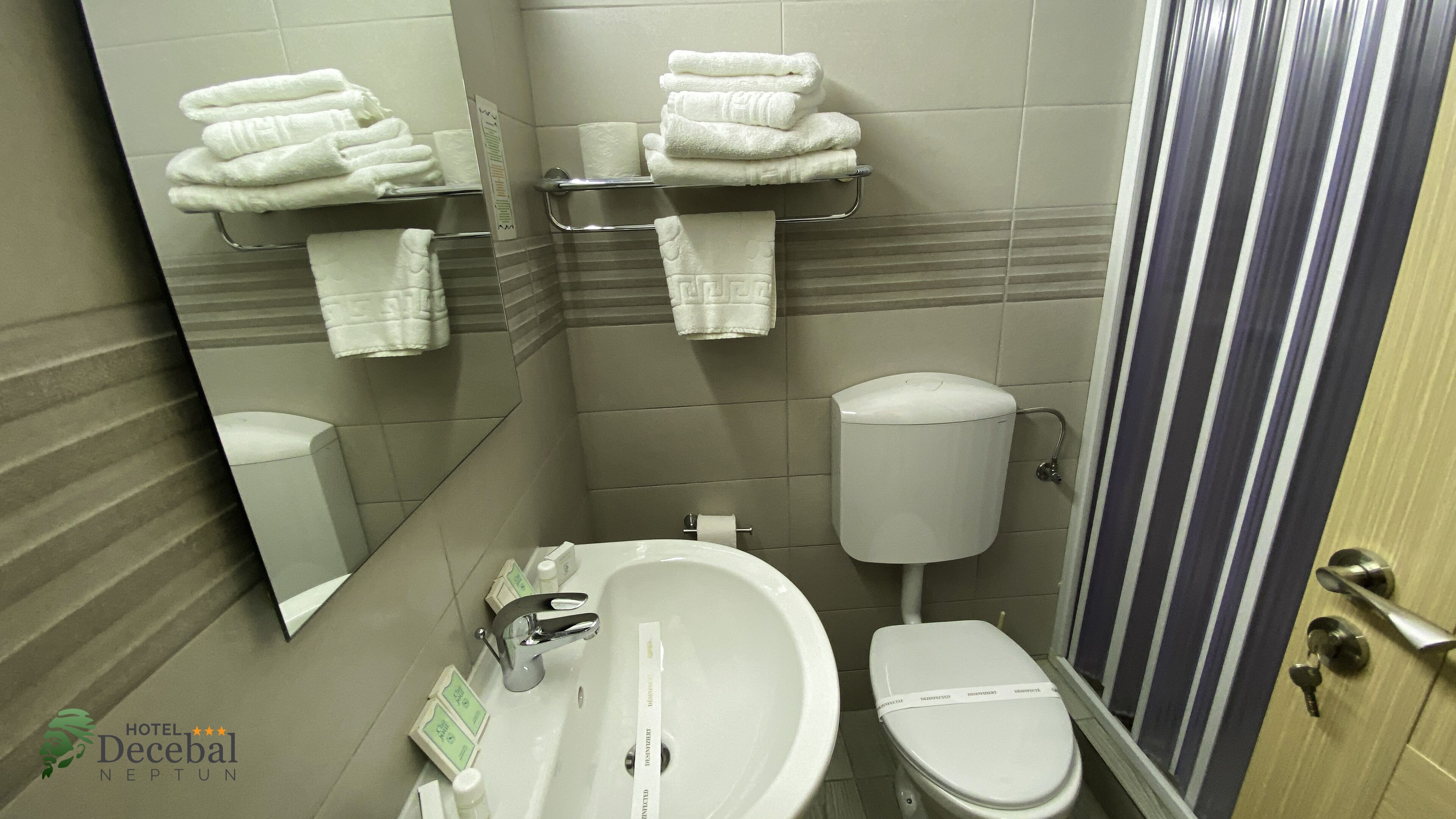 A bathroom with a toilet, sink, and towel rack.