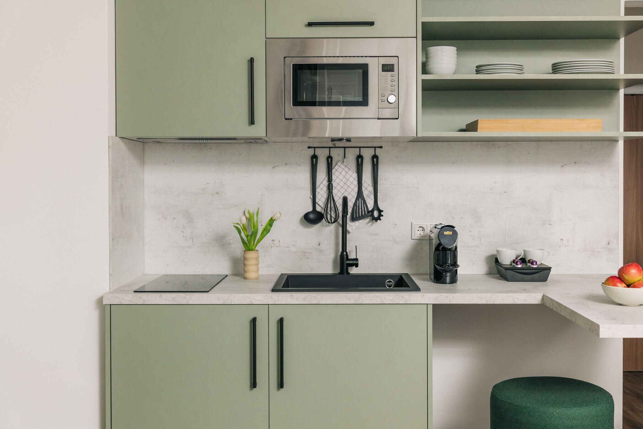 A kitchen with a built-in microwave, a sink, and a coffee maker.
