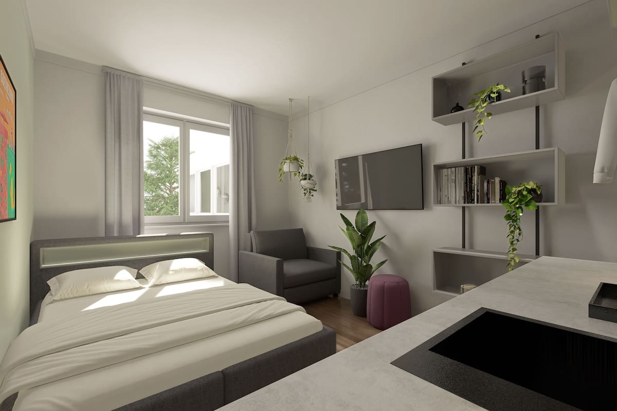 Ein modernes Hotelzimmer mit einem Bett, einem Sessel, einem Schreibtisch und einem Fernseher. Es gibt Pflanzen und Regale mit Büchern und Dekoration.