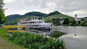 A river with boats docked, surrounded by greenery and hills. - Holiday on the Moselle in the Weinberg holiday apartment in Zell (Moselle) (Zell (Mosel))