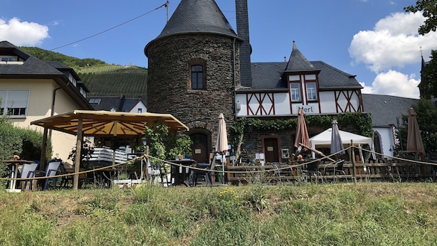 A traditional stone building with a tower, a wooden fence, and outdoor seating. - Holiday on the Moselle in the Weinberg holiday apartment in Zell (Moselle) (Zell (Mosel))