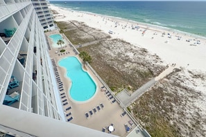 A high-rise hotel with a pool, beach, and ocean view.