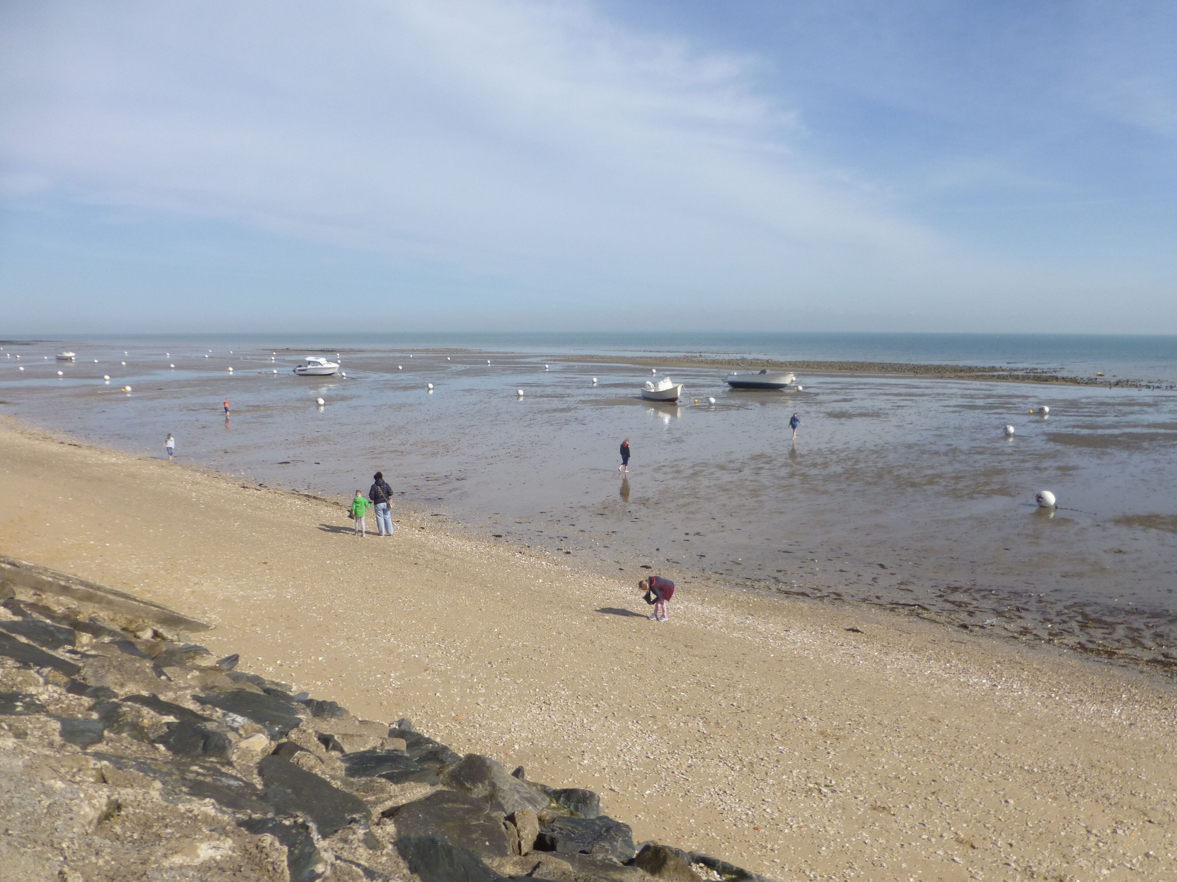 Une plage avec des bateaux et des gens.
