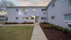 A two-story building with a flat facade, numbered C5-8, featuring a central entrance with a door and windows on each floor. - Modern 1BD Apartment Near Ferndale (Hazel Park)