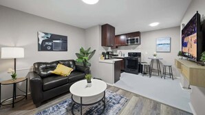 A modern apartment with a living room, kitchen, and dining area. - Modern 1BD Apartment Near Ferndale (Hazel Park)