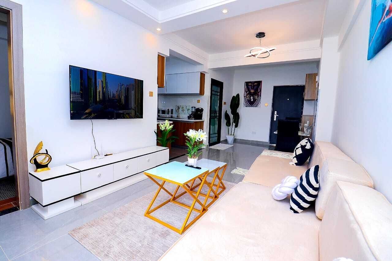 A modern living room with a sofa, coffee table, and artwork on the wall.