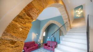 Una escalera con escalones blancos y un arco de piedra.