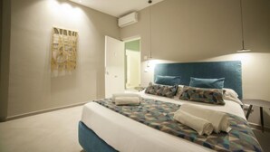 Un dormitorio moderno con una cama grande, cabecera y aire acondicionado instalado en la pared.