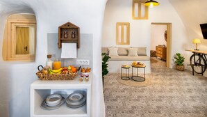 Una habitación acogedora y bien iluminada, con espacio para el desayuno, un sofá y una bicicleta.