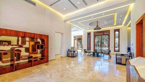 A spacious lobby with a modern reception desk, a dining area with tables and chairs, and large windows providing natural light. - Villa Mimouana Riads 18 Chambres (Marrakech)