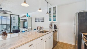 A modern kitchen with a large island, stainless steel appliances, and pendant lighting. - Includes Xplorie Activities and Linens. PYRAMID - Upgraded 2BR oceanfront condo w/outdoor pool. (Ocean City)