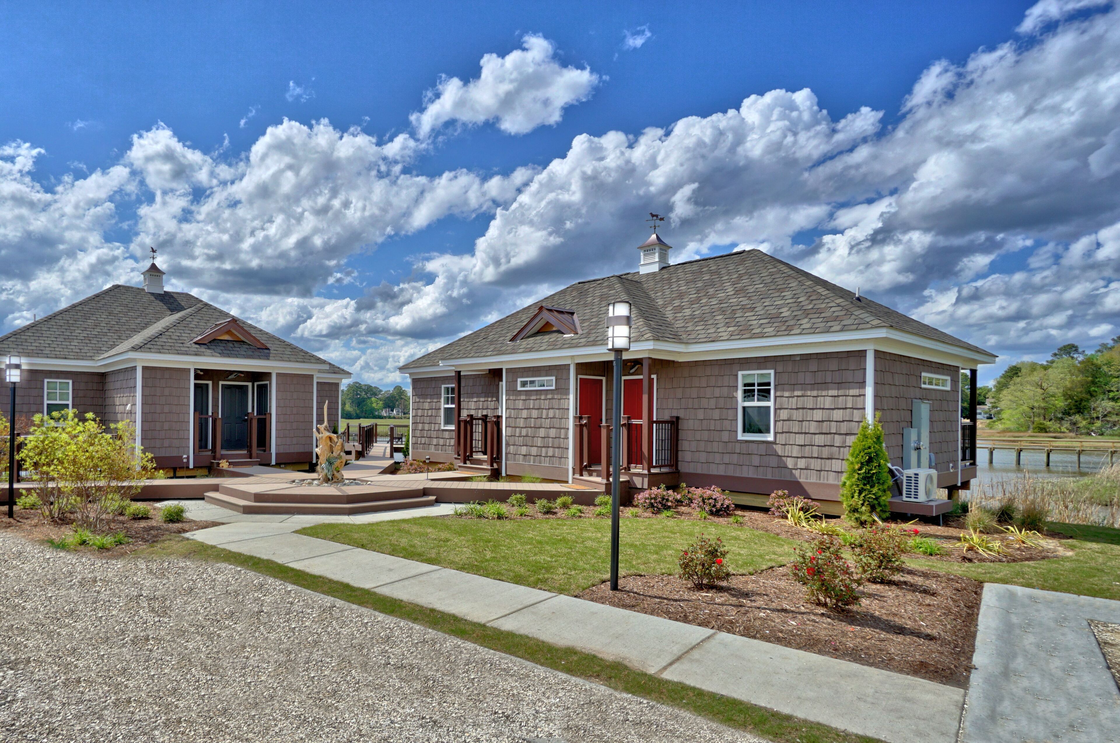 A residential property with two houses, each featuring a front porch, a chimney, and a small garden area.