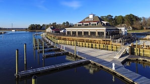 A waterfront property with a dock, a building labeled "DECOYS," and a clear blue sky. - Decoys (Suffolk)