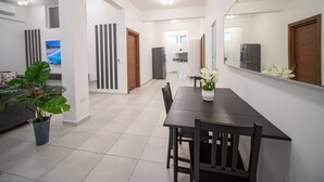 Un salon moderne avec un coin repas, un grand miroir et une plante en pot.