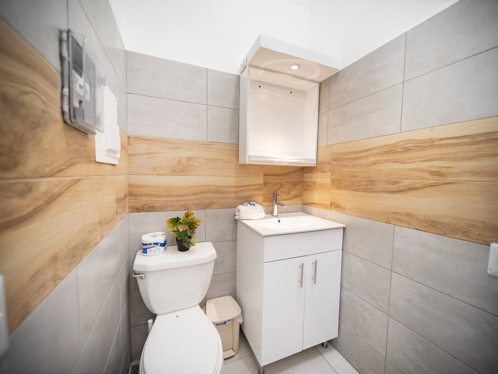 A modern bathroom with a toilet, sink, and cabinet.