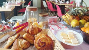 Un bufé de desayuno con pasteles, frutas y salsas.
