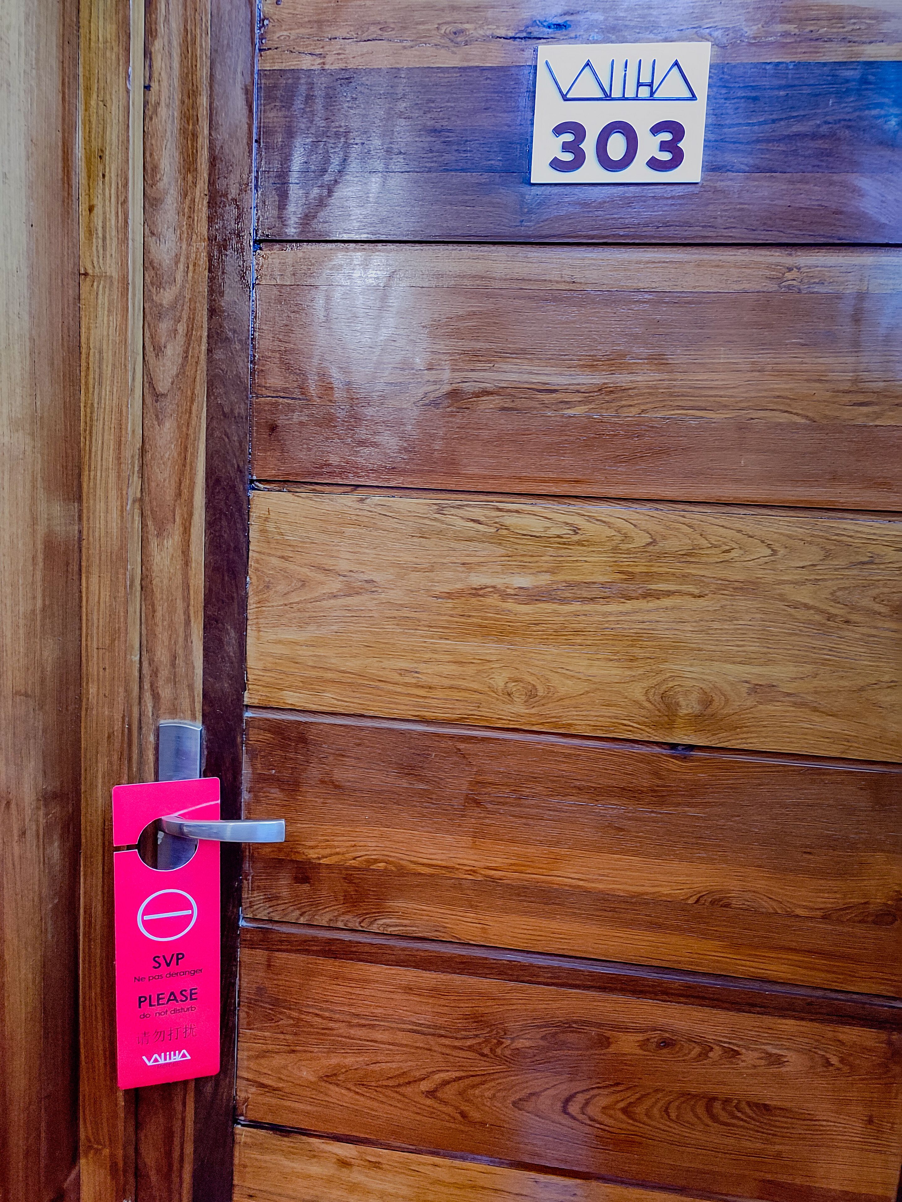 A wooden door with a number sign and a lock.