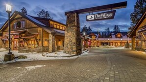 Eine Lodge mit Steineingang, Holzfassade und einem Schild mit der Aufschrift 'The Village at Sunriver'.