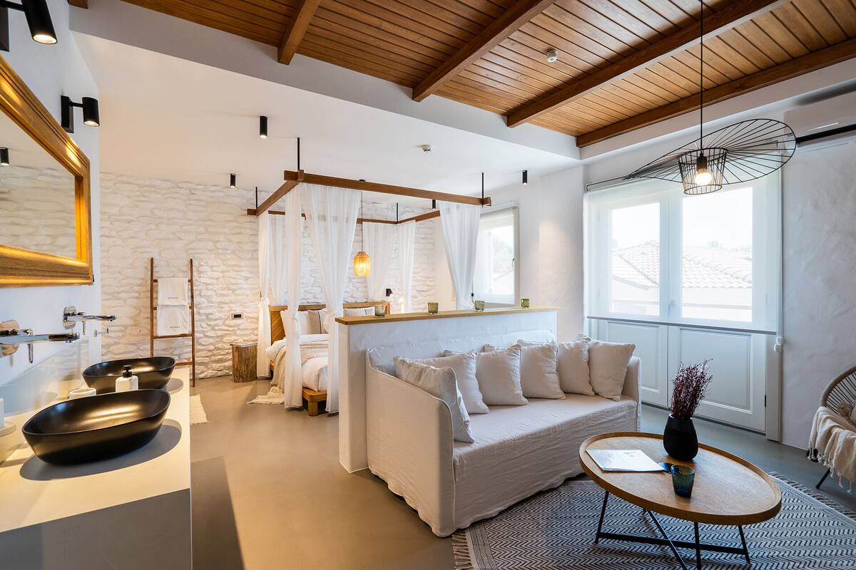 A modern bedroom with a bed, bedside table, and a large window.