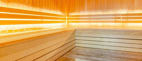 A sauna with wooden benches and a warm, illuminated interior.