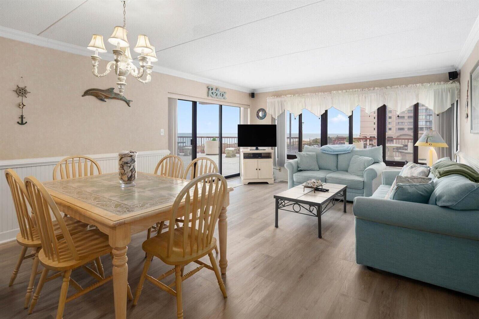 A spacious living room with a dining area, a sofa, and a television.