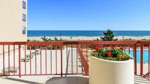 A balcony with a view of the beach and ocean.