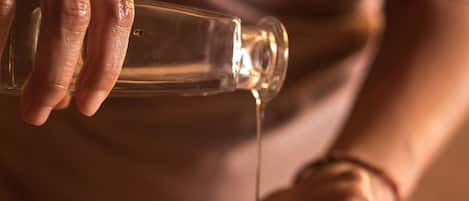 A person pouring a clear liquid from a bottle into their hands.